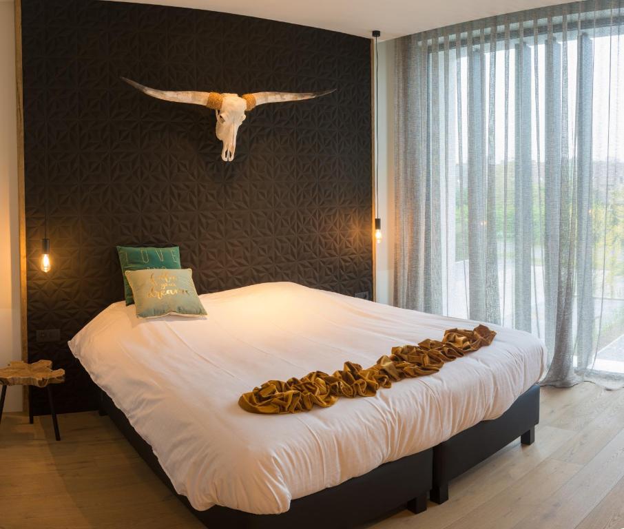 蒂尔特沙姆洛克酒店的卧室配有一张大床,墙上挂着雕塑