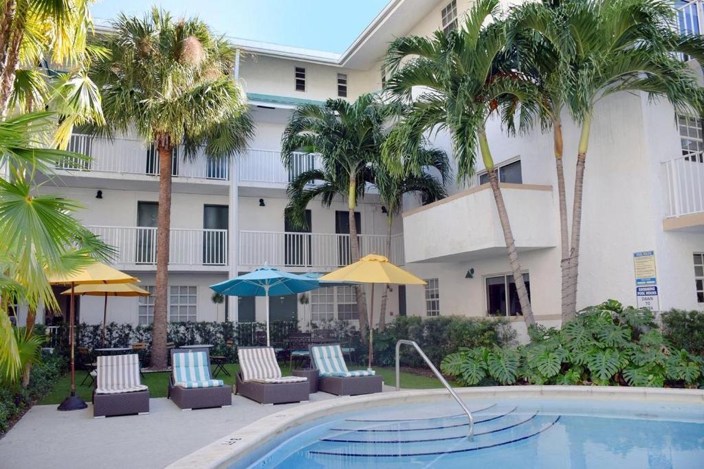 迈阿密Suites at Coral Resorts的酒店设有带椅子和遮阳伞的游泳池