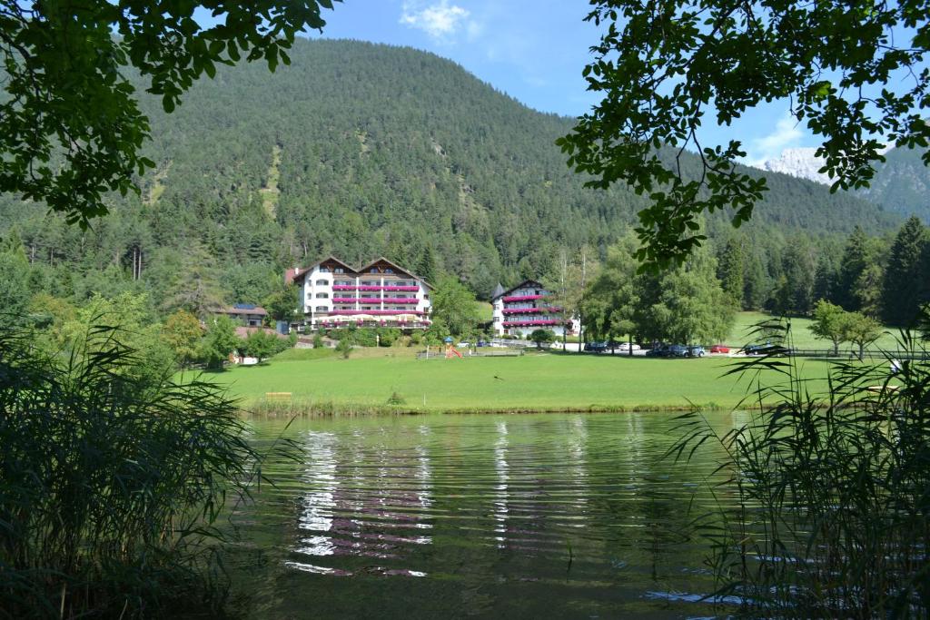 伊姆斯特Linserhof Bed&Breakfast的享有带湖泊和建筑的度假村景色