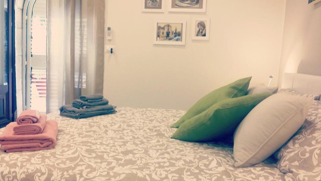 陶尔米纳Casa Cleone的床上配有枕头和毛巾