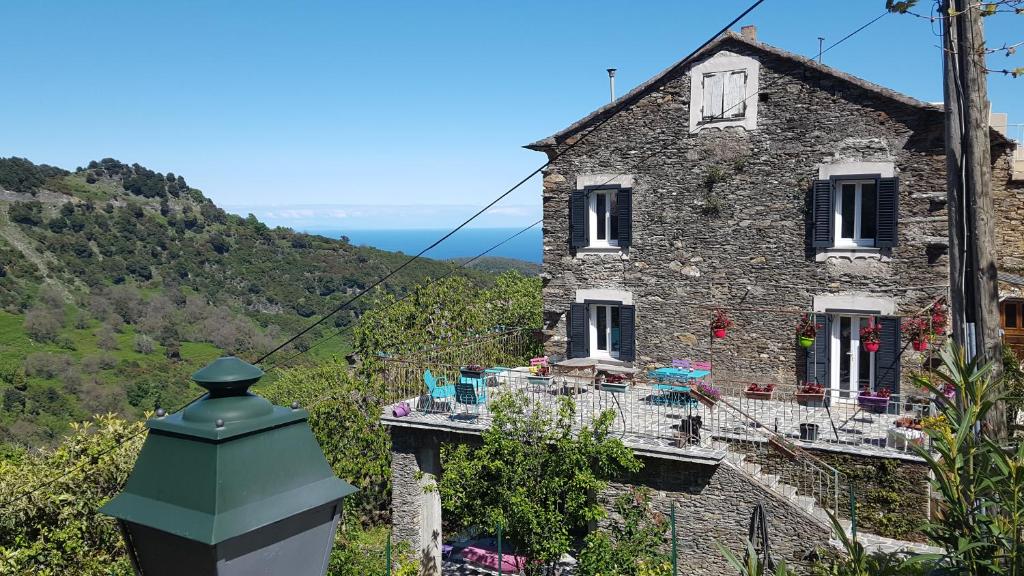 PorriEnglish Club in Corsica B&B的一座带绿色塔楼且古老的石头房子