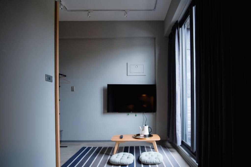 基隆粼鸟旅宿的客厅配有桌子和电视