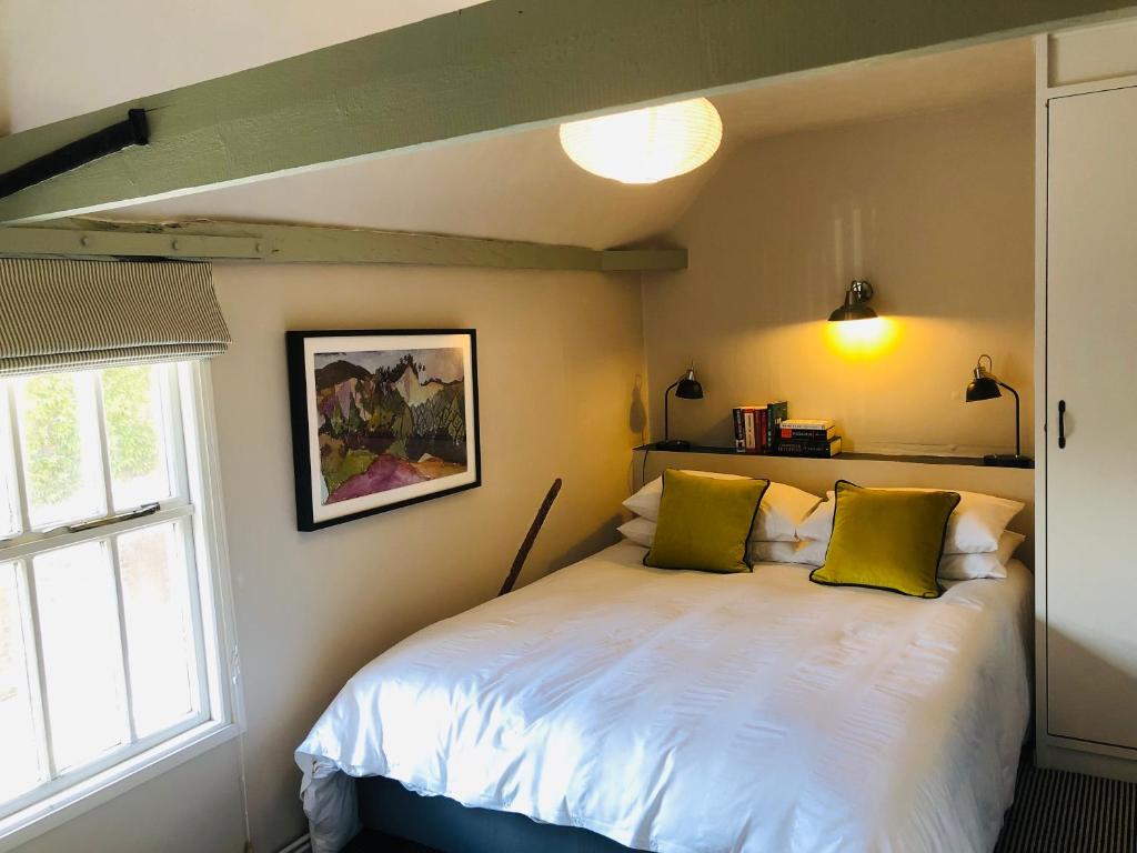 巴特尔Tudor House的一间卧室配有白色床和黄色枕头