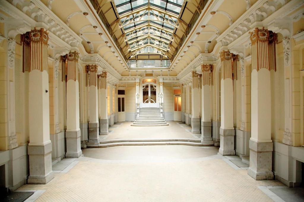 布达佩斯玛维里克旅馆及套房的建筑中空的走廊,有柱子和玻璃天花板