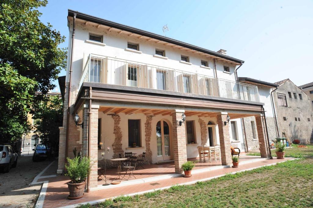 Marmirolo伊尔加迪诺德尔金帝库斯托扎酒店的一座大型白色房子,前面设有一个庭院