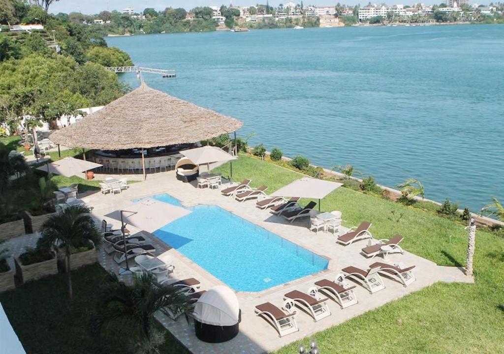 蒙巴萨城市蓝溪边酒店和套房的享有带椅子和遮阳伞的游泳池的上方景色