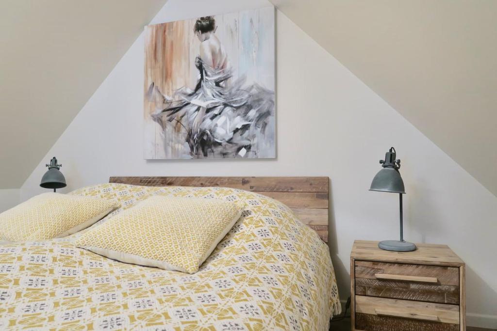 ContinvoirCountry House - La Valentrée的卧室配有一张床,墙上挂有绘画作品