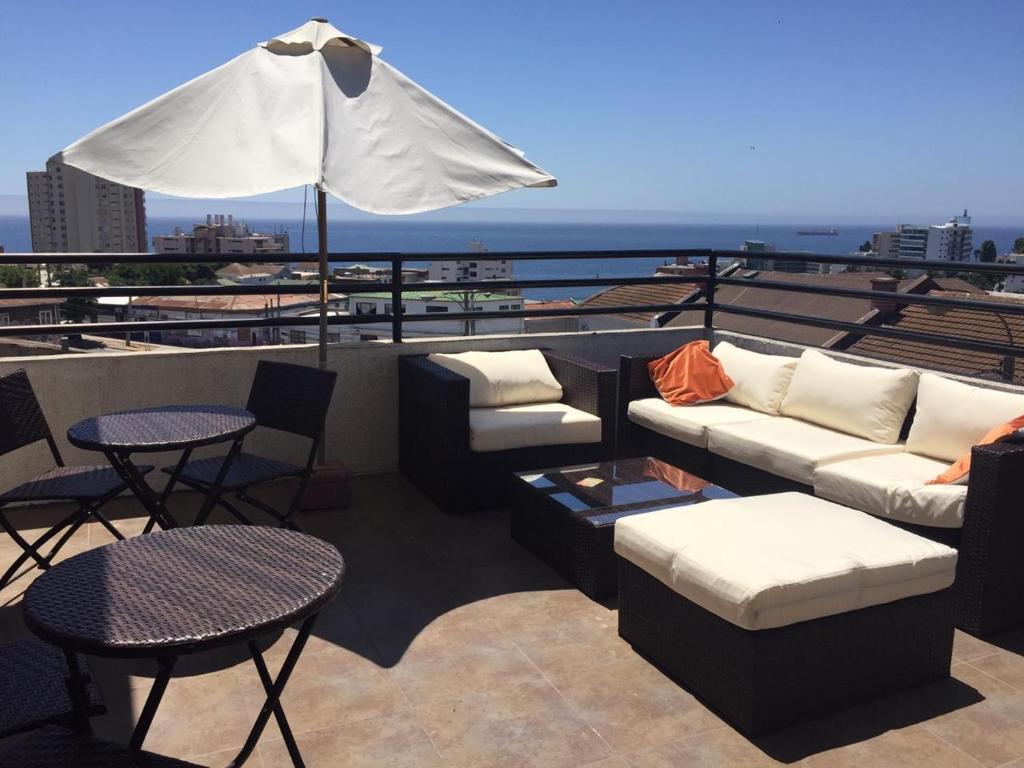 维纳德马B&B Hostel CasaMoro的屋顶庭院配有沙发、桌子和遮阳伞。