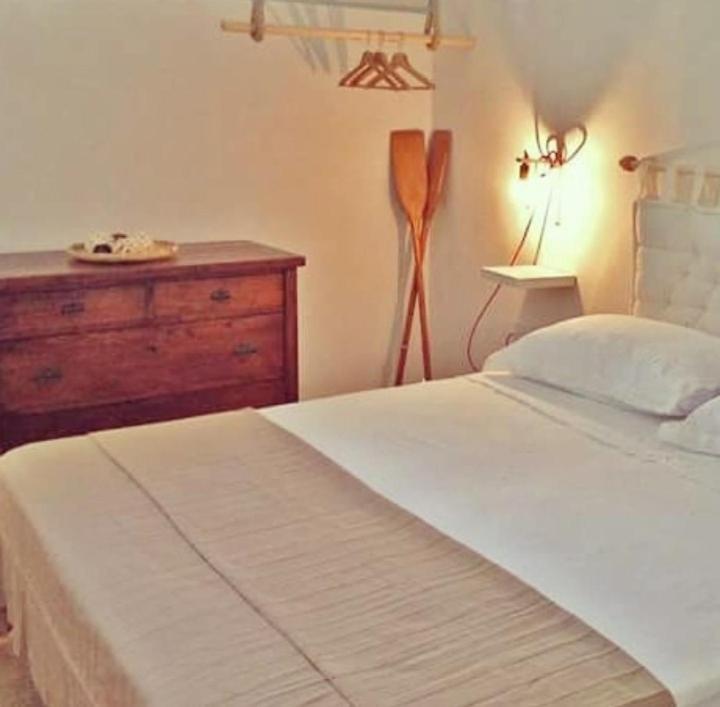 帕图Villa del mar的卧室配有白色的床和木制梳妆台。