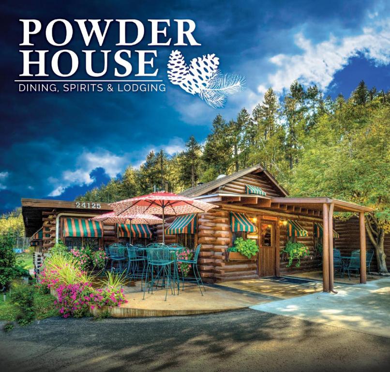奇斯顿Powder House Lodge的木房子杂志封面,带门廊和庭院
