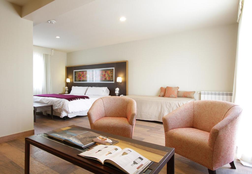查克拉斯德科里亚天堂广场佩蒂酒店的酒店客房配有一张床、两把椅子和一张桌子