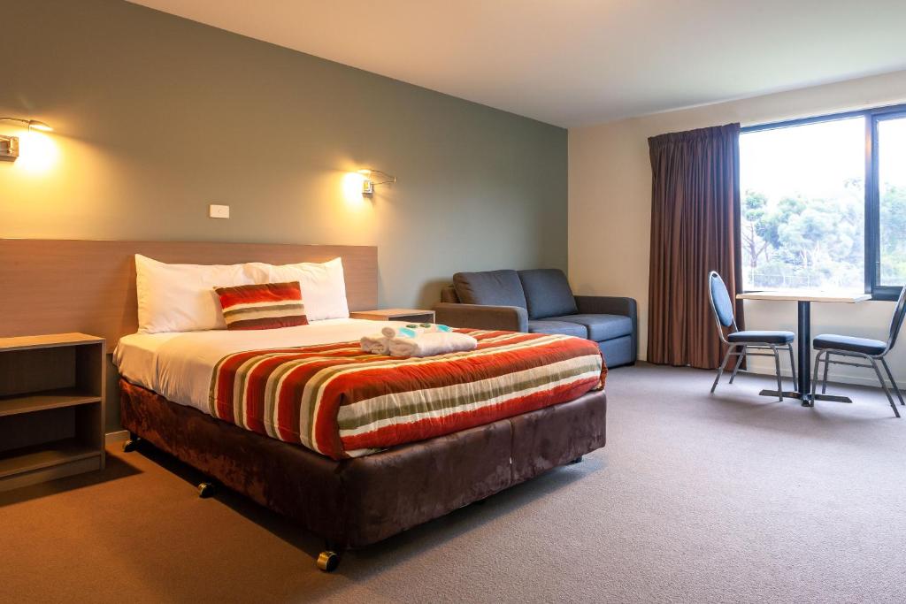 金斯顿Kingston hotel Motel的酒店客房配有一张床、一把椅子和一张书桌