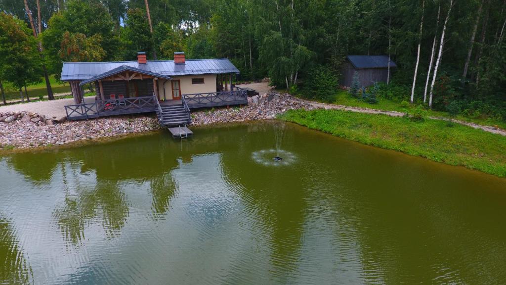 CesvaineDzirnavas Pirtsmāja的湖中的小房子