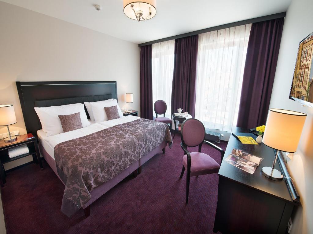 布拉格布拉格EA大使酒店的酒店客房,配有一张床、一张桌子和椅子