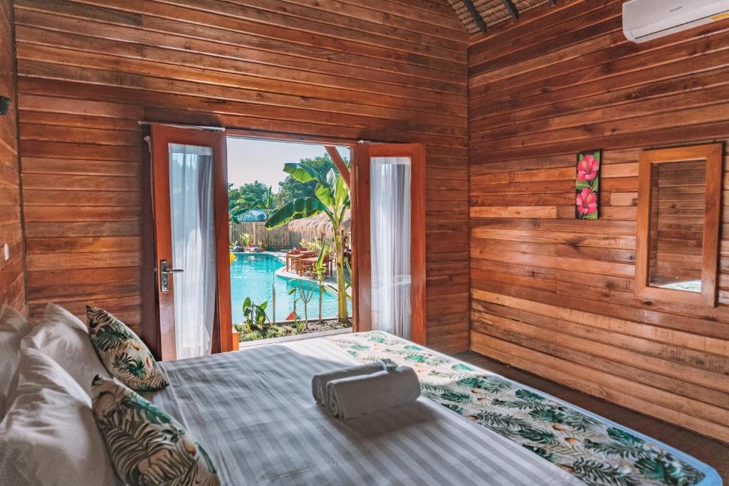 吉利特拉旺安Voodoo Gili的一间卧室设有一张床,享有游泳池的景色