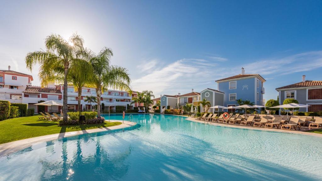 EsteponaCortijo Del Mar Resort的一座带椅子和棕榈树的度假村游泳池