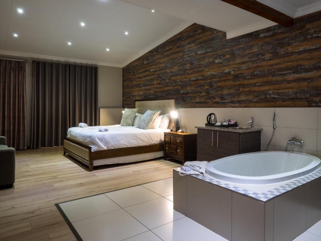 塞昆达Hotel @ Secunda的一间卧室配有一张床和浴缸