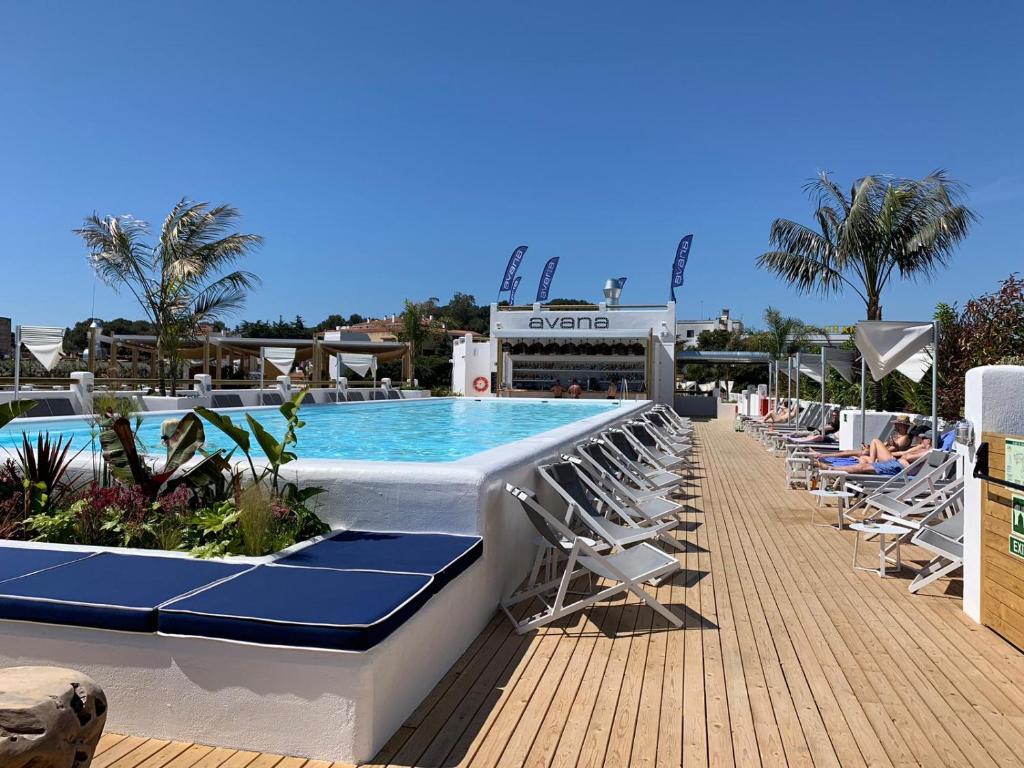 罗列特海岸Gran Hotel Flamingo-Adults Only的毗邻度假酒店的带躺椅的游泳池