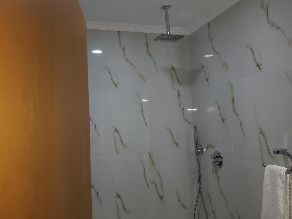 Rinas瓦萨奇酒店的一间设有白色大理石墙壁和淋浴的浴室