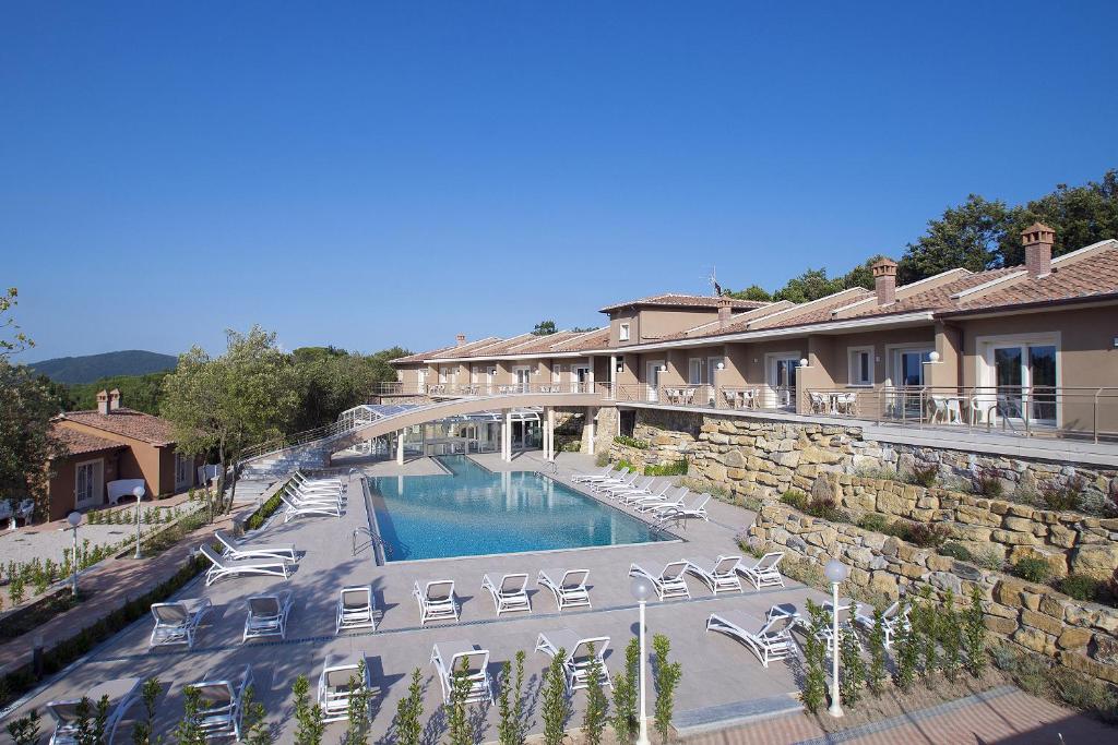 蒙泰韦尔迪马里蒂莫Relais I Piastroni的一个带椅子和桥梁的游泳池的度假酒店