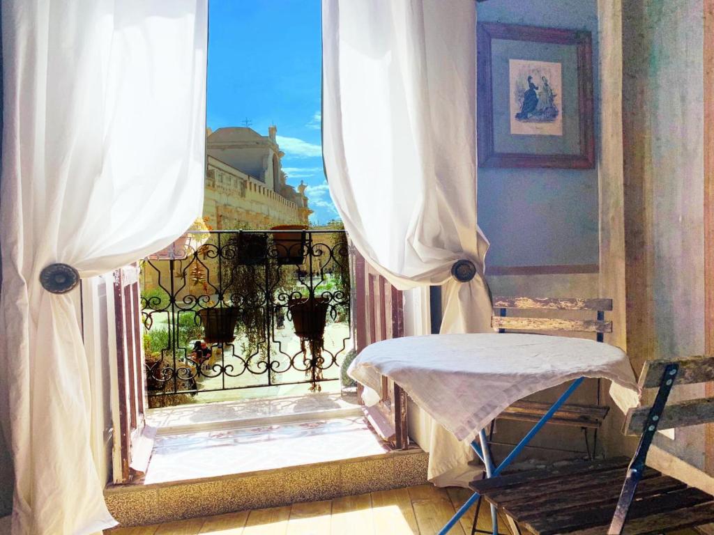 锡拉库扎萨洛托玛丽亚皮娅旅馆的客房设有带椅子和窗户的阳台。