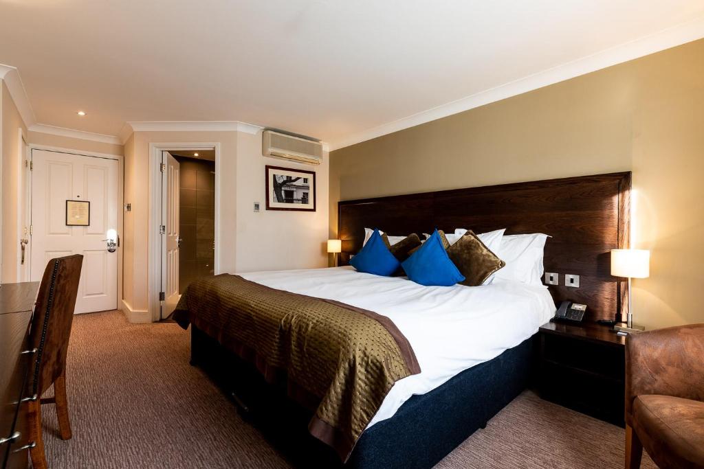 伦敦玫瑰与皇冠酒店的酒店客房配有一张带蓝色枕头的大床