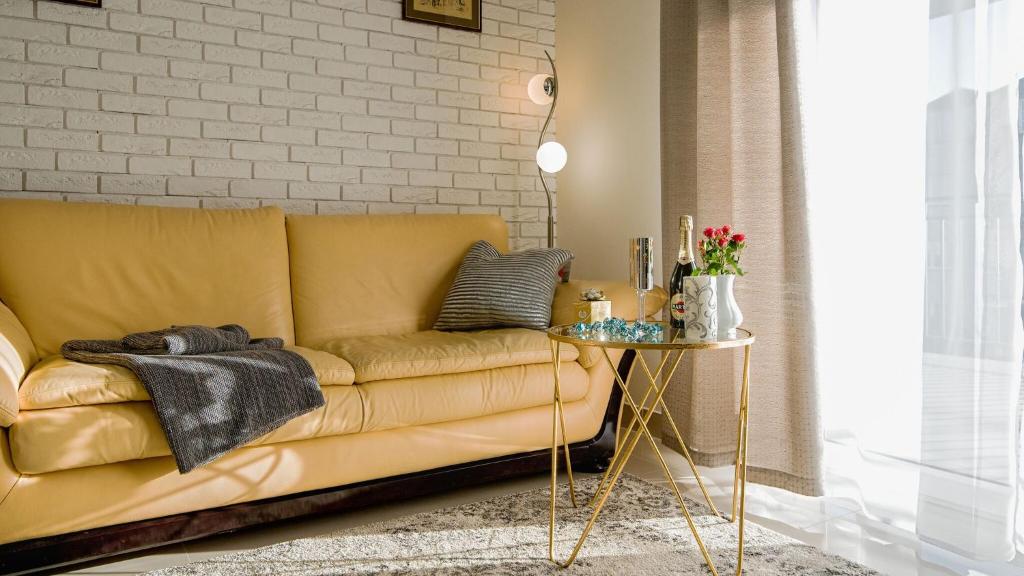 拉辛Aparthotel Koroni Home的客厅配有黄色的沙发和桌子