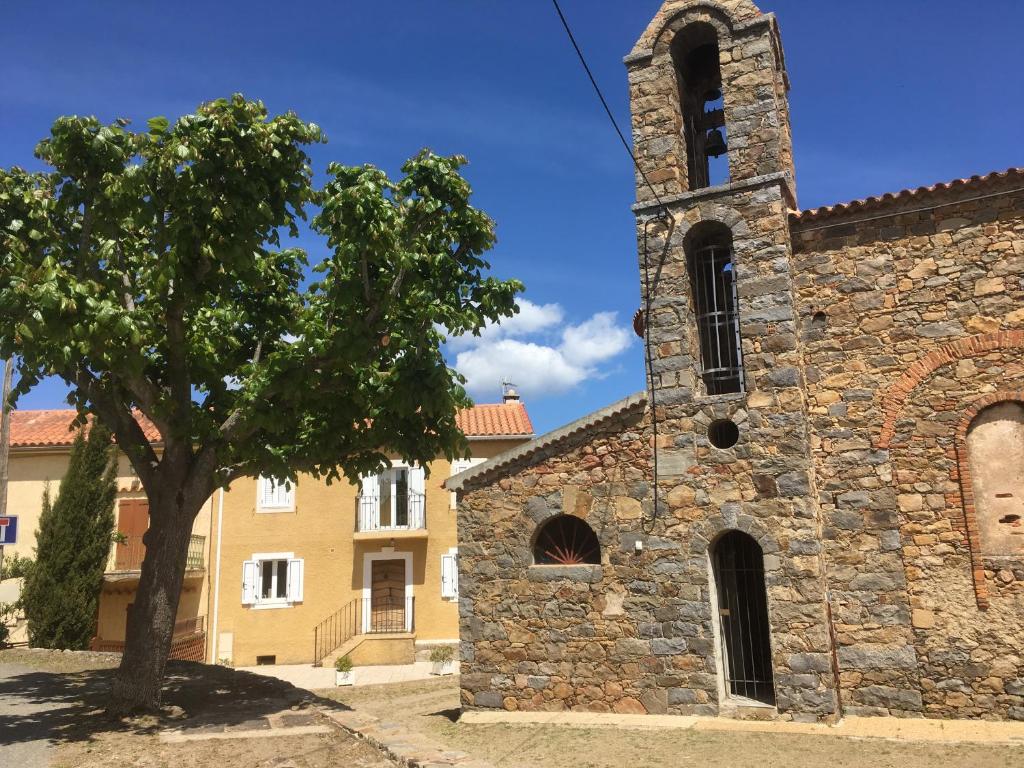 萨里索伦札拉indé no的一座古老的石头教堂,前面有一棵树