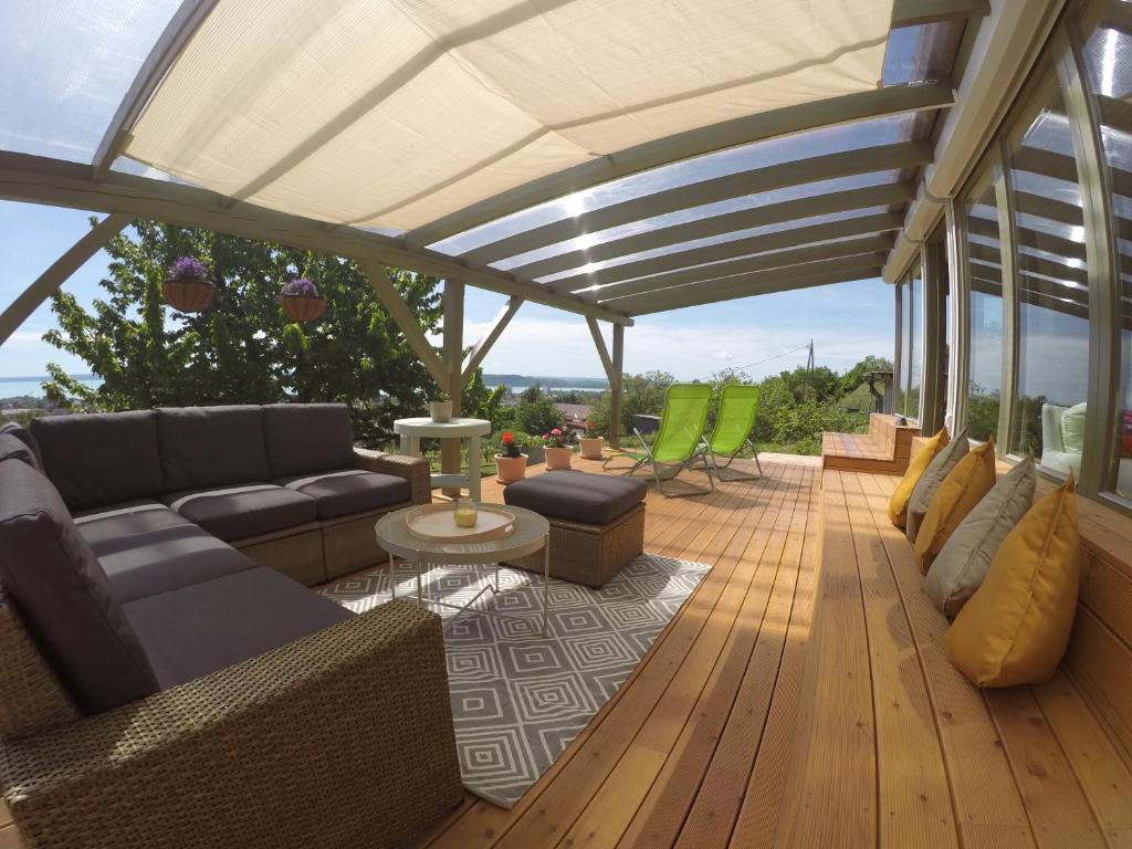 巴拉顿菲赖德Balaton View Residence的木制甲板上配有沙发和椅子的庭院