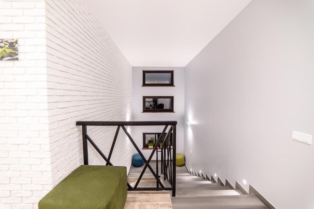乌日霍罗德Is’land Hostel的白色砖墙旁的带绿色搁脚凳的楼梯