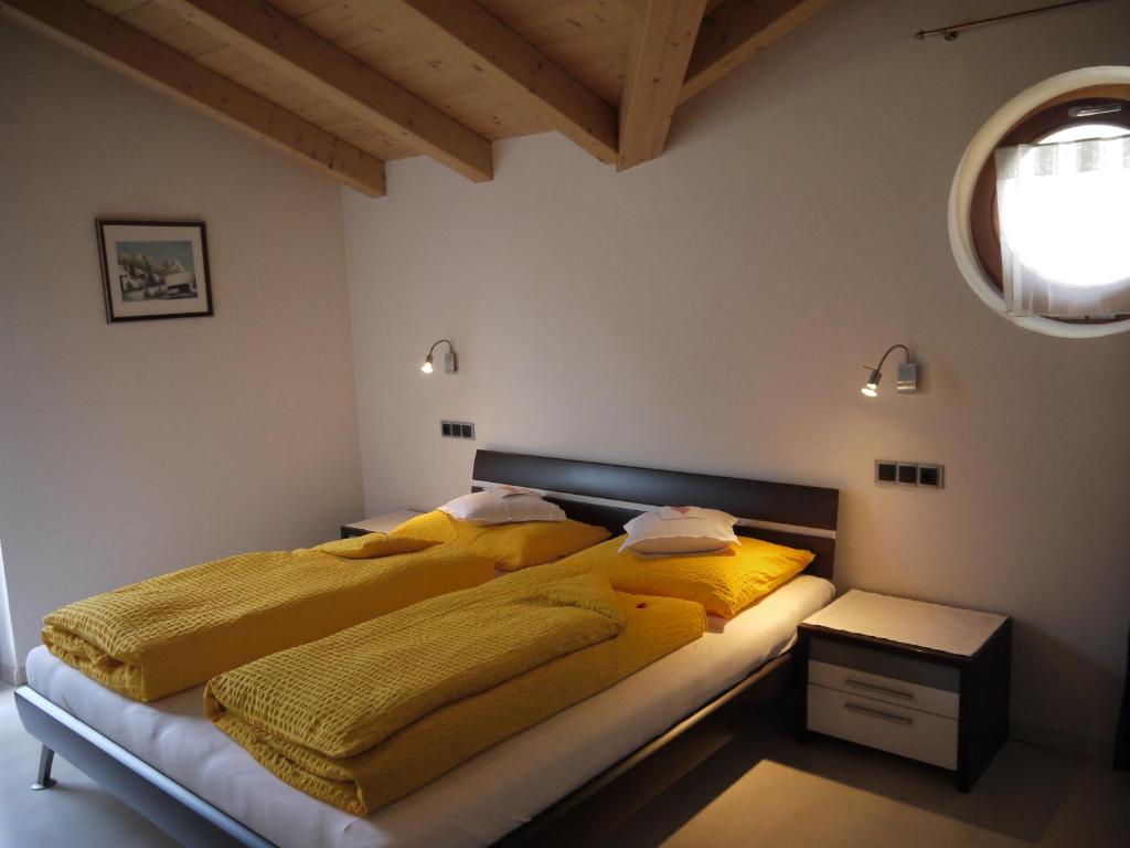 坎波图雷斯Hörtmairhof的一间卧室设有两张带黄色毯子和窗户的床。