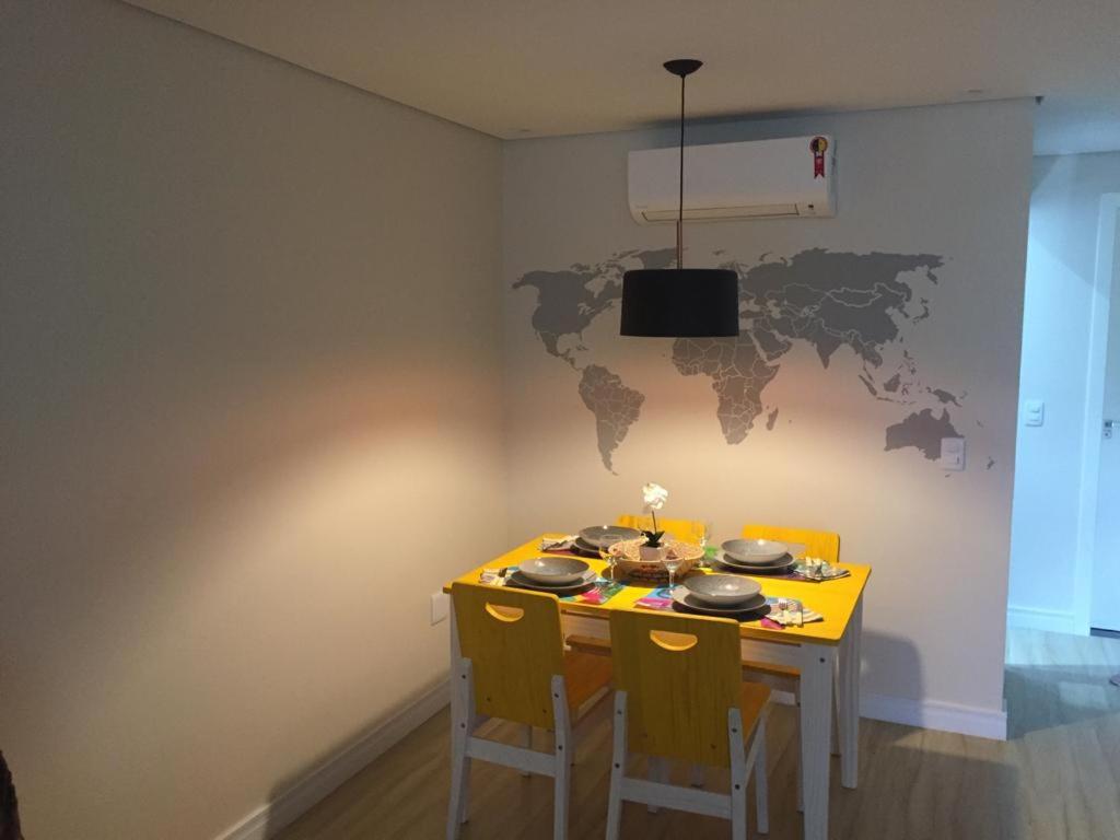 巴西利亚Charmoso e Confortável的餐桌、椅子和墙上的世界地图
