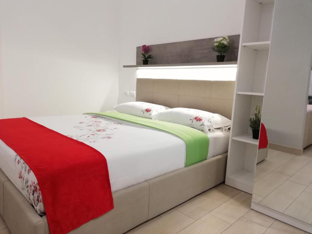 米兰Rogoredo Milan Apartments的一间卧室配有一张带红色和绿色毯子的床