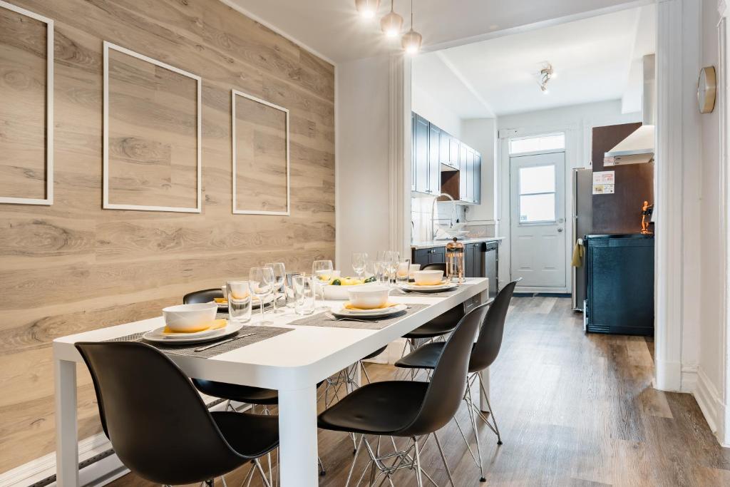 蒙特利尔Apartments Near Montreal Olympic Park的一间配备有白色桌子和黑色椅子的用餐室