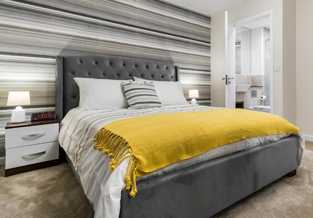 查塔姆Fortified Luxury Apartment的一间卧室配有一张带黄色毯子的大床