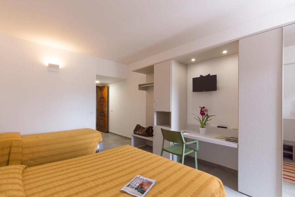 多尔加利Hotel Ispinigoli的酒店客房 - 带一张床和用餐室