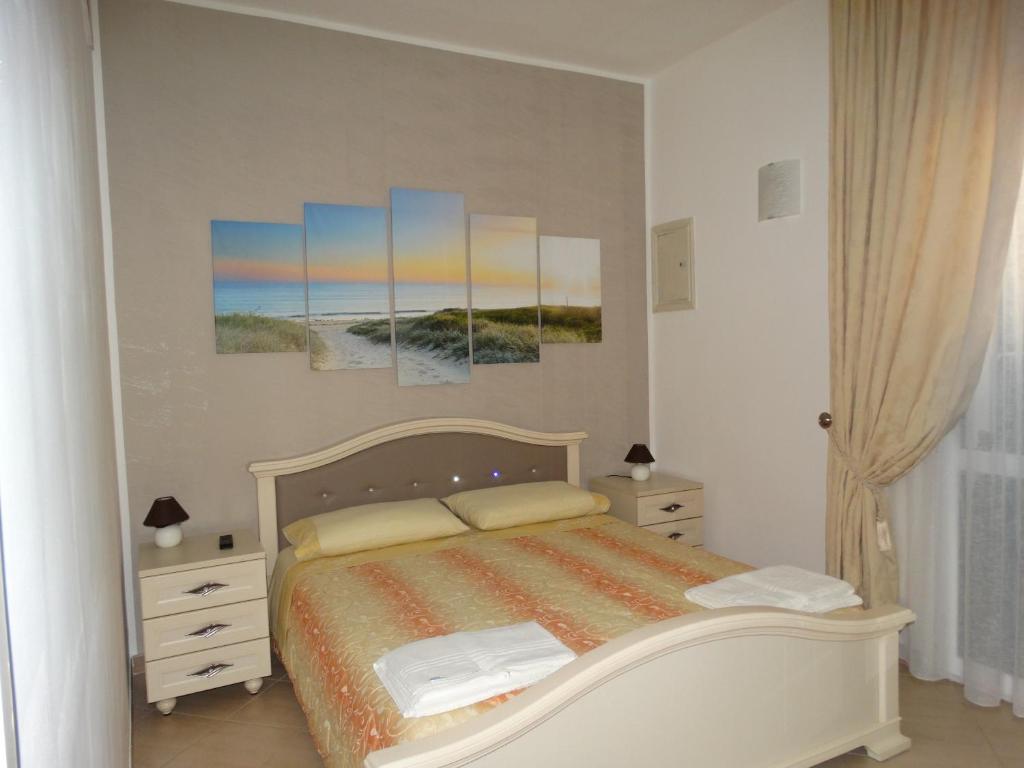 切萨雷奥港Relax Affittacamere的卧室配有一张床,墙上挂有绘画作品