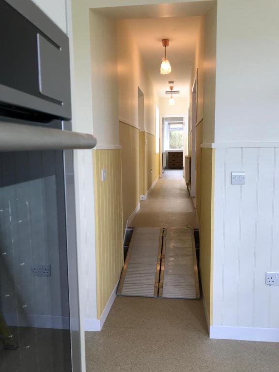 瑟索Bayview Cottage, Dunnetbay accommodation的走廊设有长长的走廊,铺有木地板
