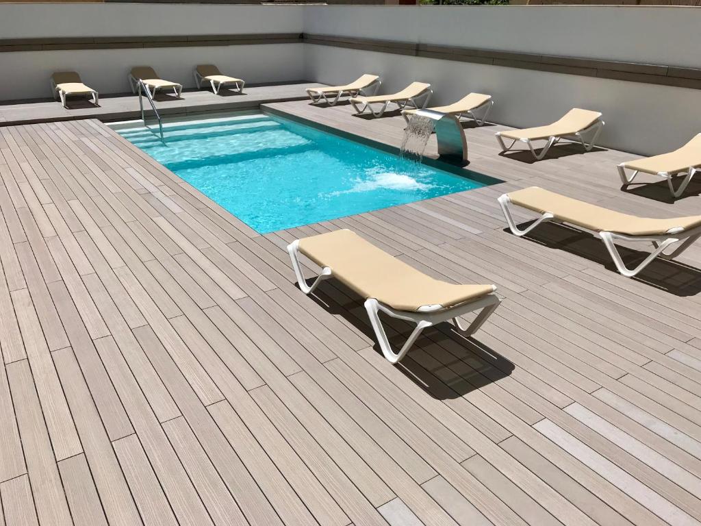 埃尔阿雷纳尔格拉西亚酒店的一个带躺椅和一排阴茎的游泳池