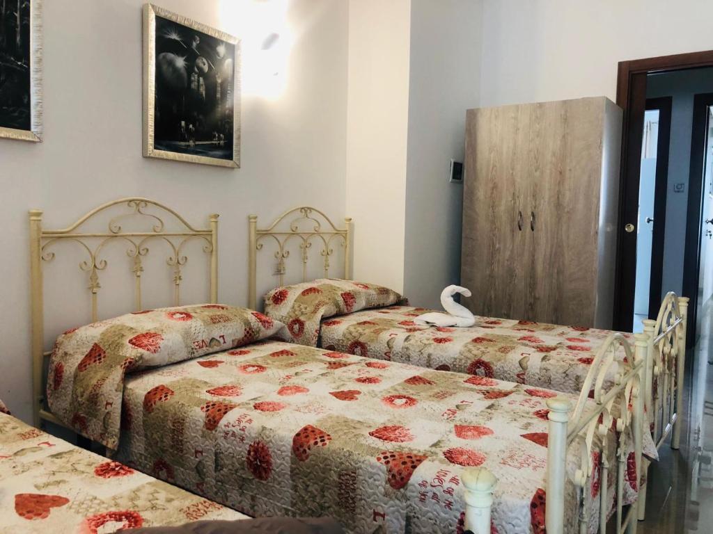 阿莱齐奥La casa di Chloé的一间卧室配有两张床,床上有天鹅