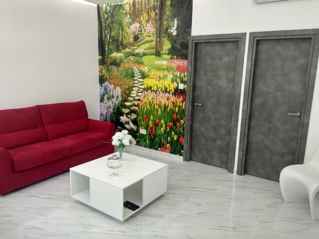 利马索尔2 Brothers的客厅配有红色的沙发和一幅鲜花画