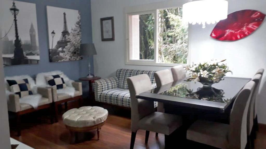 格拉玛多Glamour Gramado Residence的客厅配有桌椅和沙发