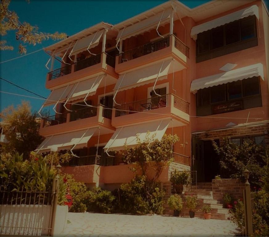 卡拉米锡Nontas Home的一座橙色的建筑,前面设有楼梯