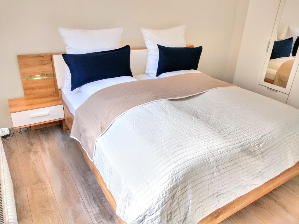 耶弗尔Friesenbude Deluxe的卧室配有带蓝色枕头的大型白色床