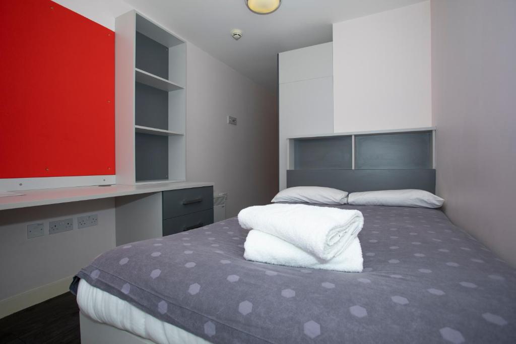 爱丁堡比佛班克广场 - 校园公寓的一间卧室配有带两个枕头的床和电视