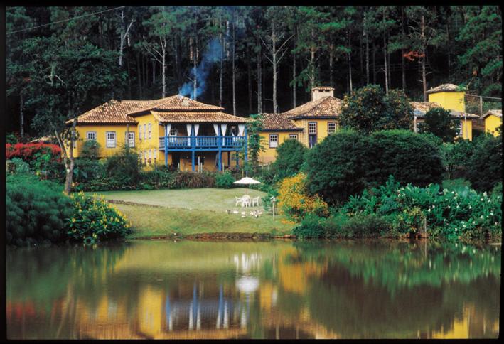 圣安娜-杜斯蒙蒂斯圣玛丽亚农家乐的水边的黄色大房子