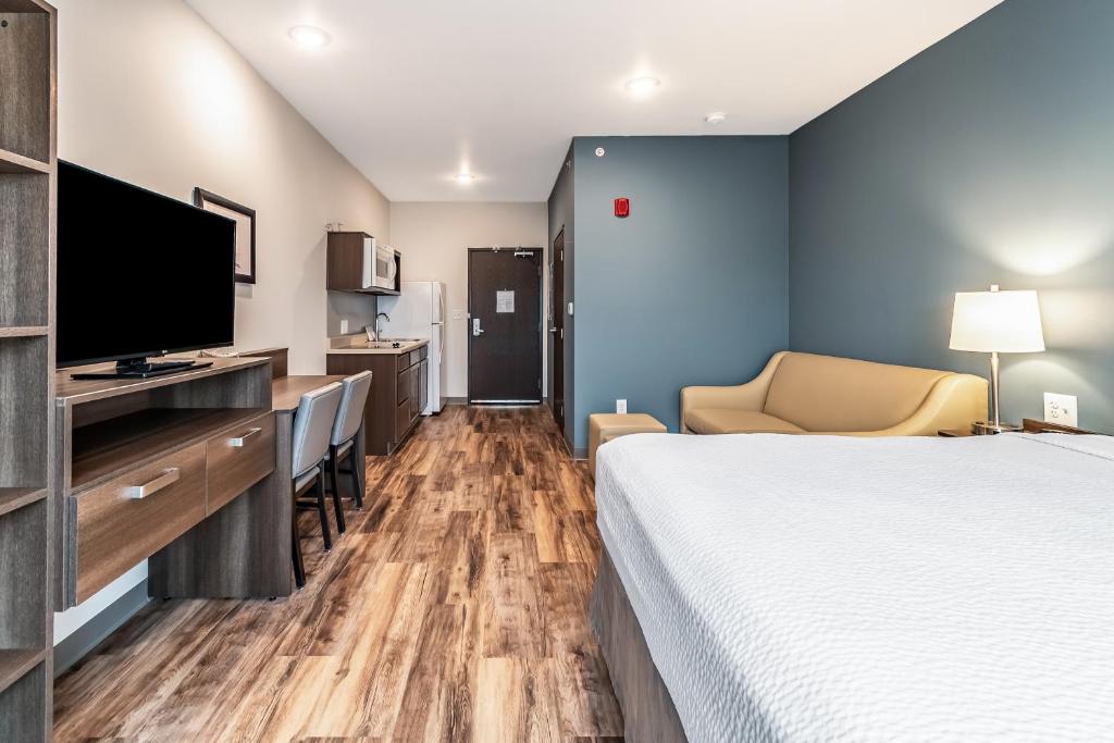 WhitestownWoodSpring Suites Indianapolis Zionsville的配有一张床和一台平面电视的酒店客房