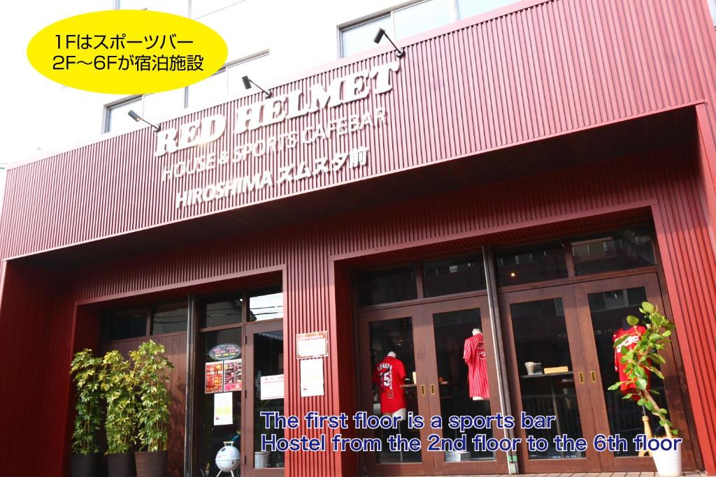 广岛RED HELMET House & Sports Bar Hiroshima的红色的建筑,上面有一层的标志,是体育运动的标志