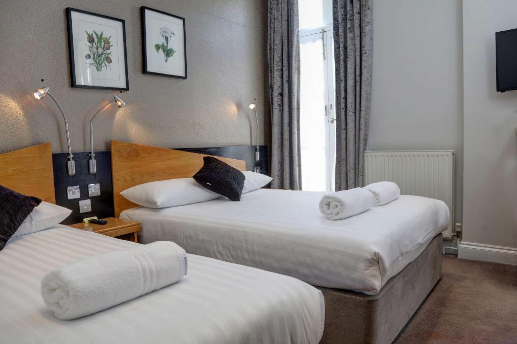 伦敦Best Western Buckingham Palace Rd的酒店客房,配有两张带毛巾的床