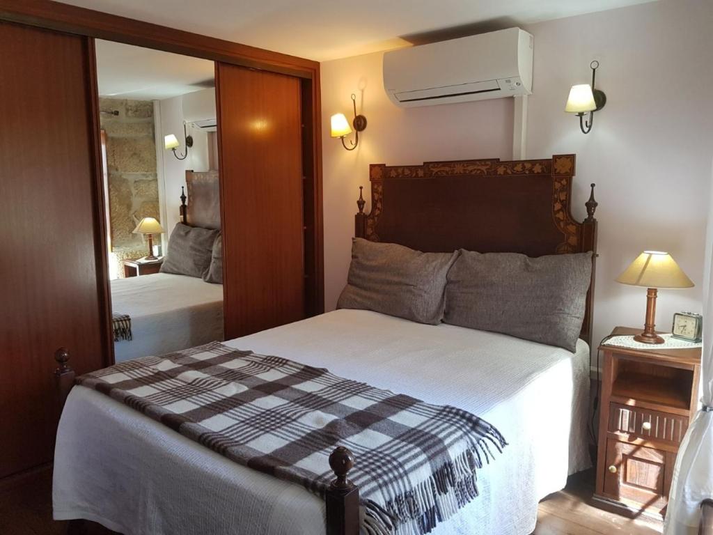 戈韦阿A Casinha do Beco的一间卧室配有一张大床和镜子
